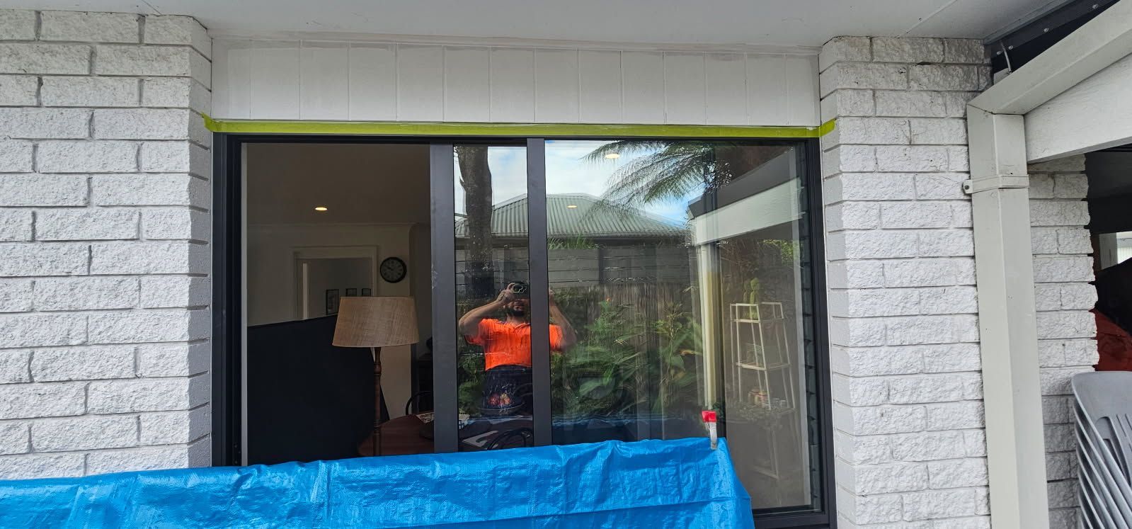 A man is standing in front of a sliding glass door.