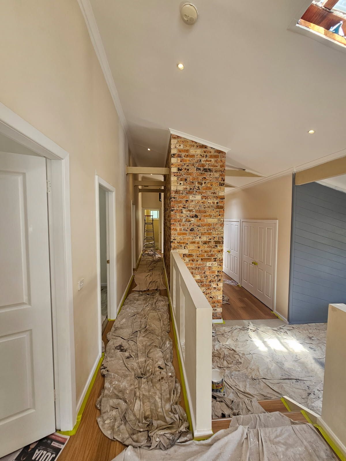 A hallway with a brick chimney in the middle of it