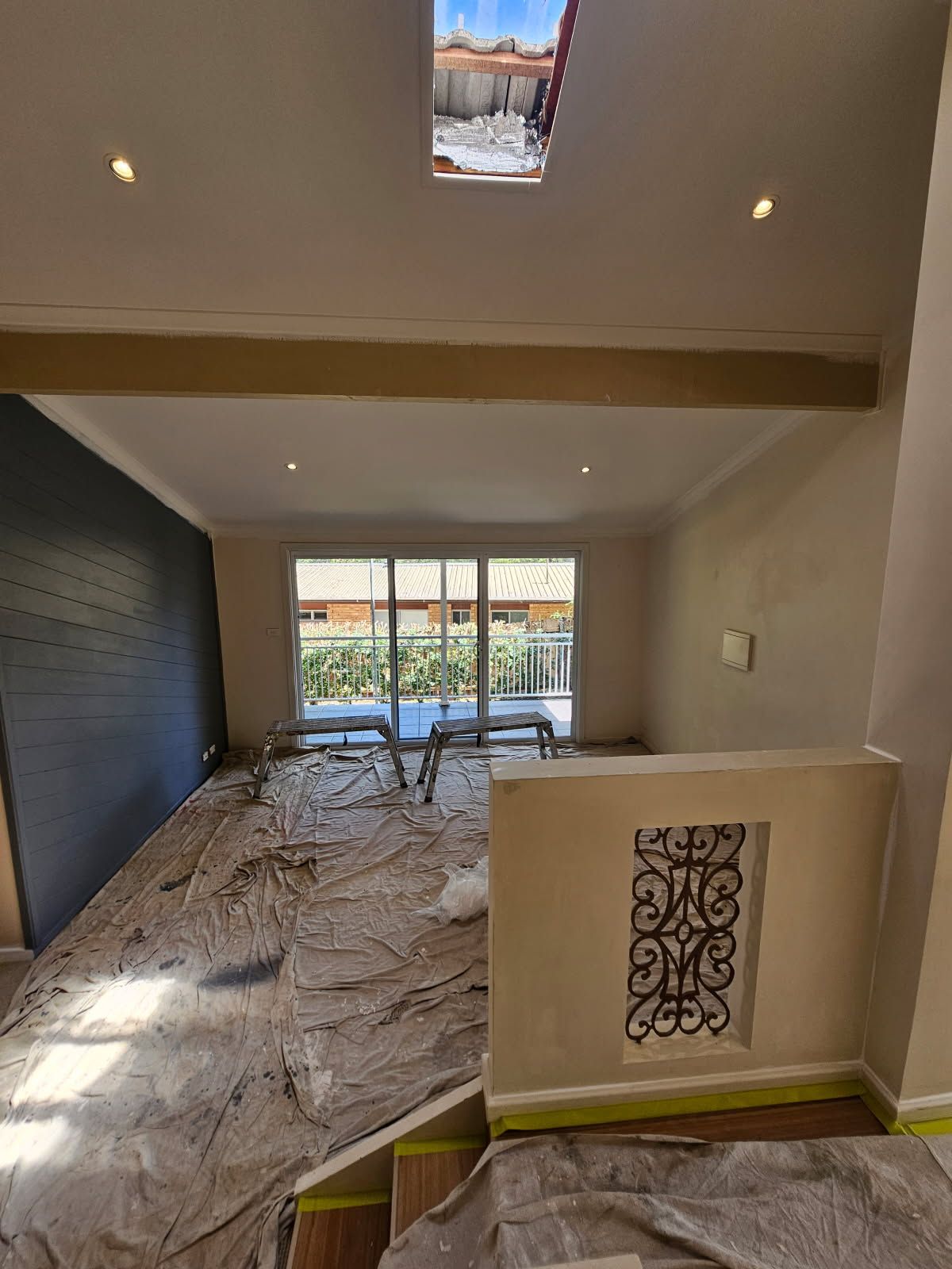 A living room with a lot of windows and a skylight in the ceiling.