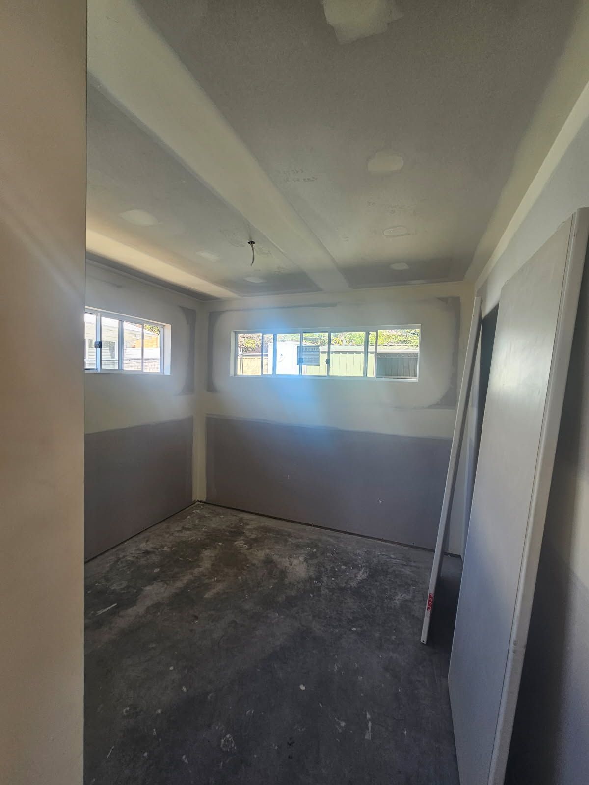 An empty room with a lot of windows and a ceiling.