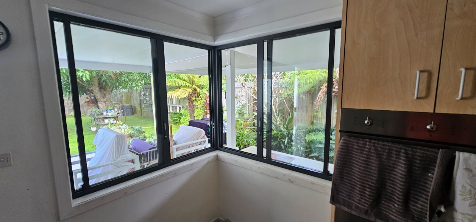 A kitchen with a lot of windows and a clock on the wall.