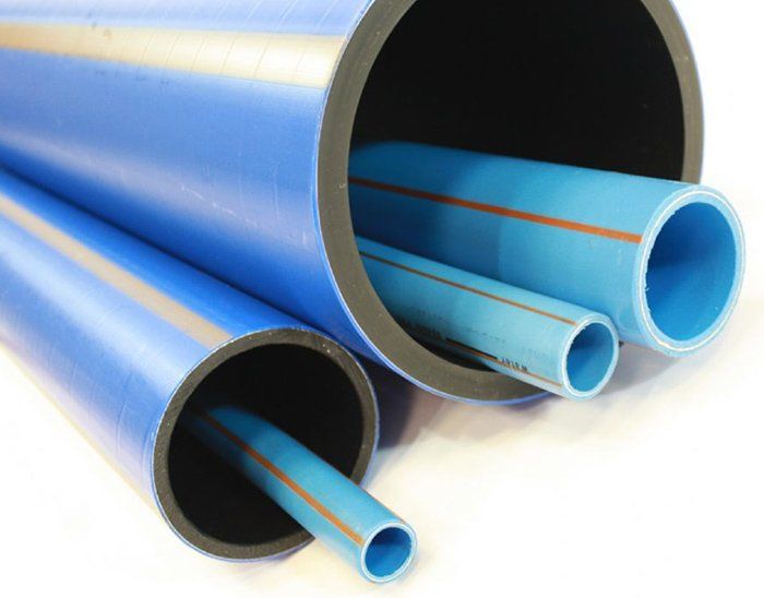 Three blue pipes are stacked on top of each other on a white surface