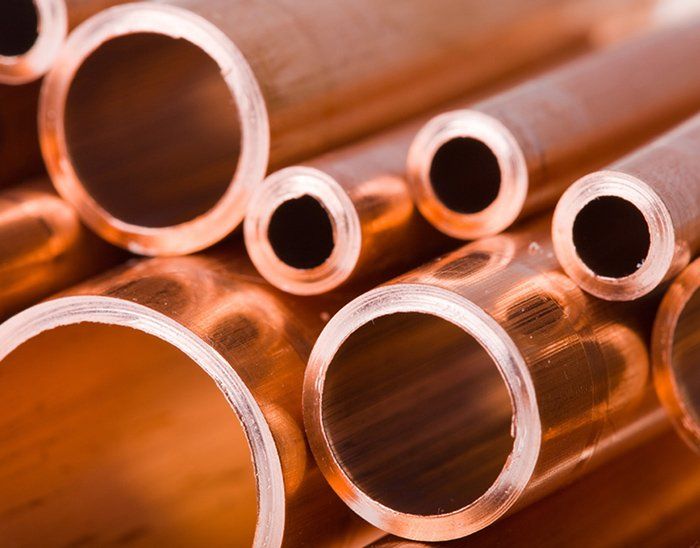 A bunch of copper pipes are stacked on top of each other