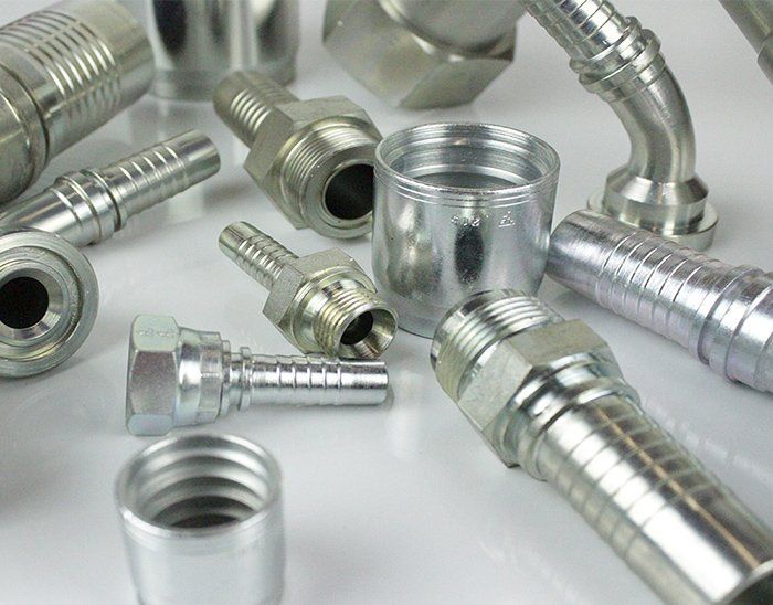 There are many different types of hydraulic fittings on the table.