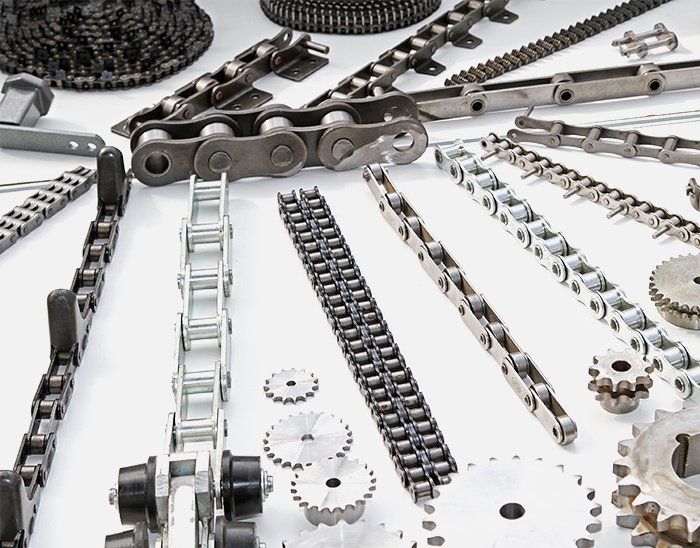 A bunch of chains and gears on a table. Power Transmission