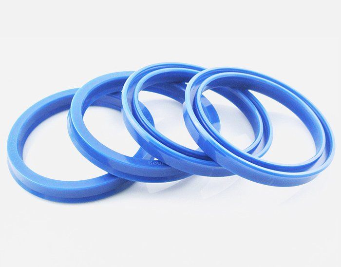 Four blue rubber rings are stacked on top of each other on a white surface.