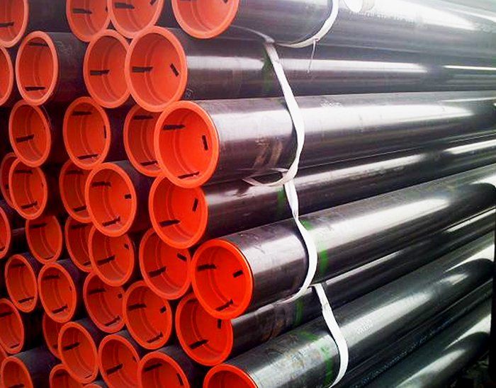 A pile of black pipes with red caps stacked on top of each other.