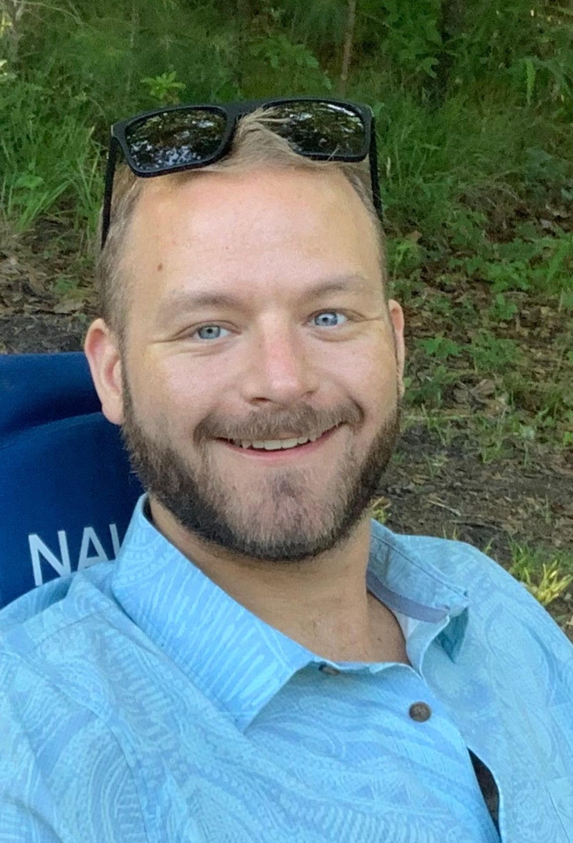 A man in a tuxedo and bow tie is smiling while a woman holds his hand on his chest.