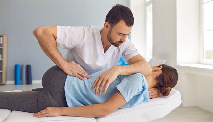 A man is giving a woman a massage on a bed.
