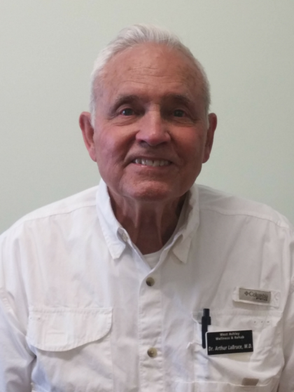 An older man wearing a white shirt with a pen in his pocket