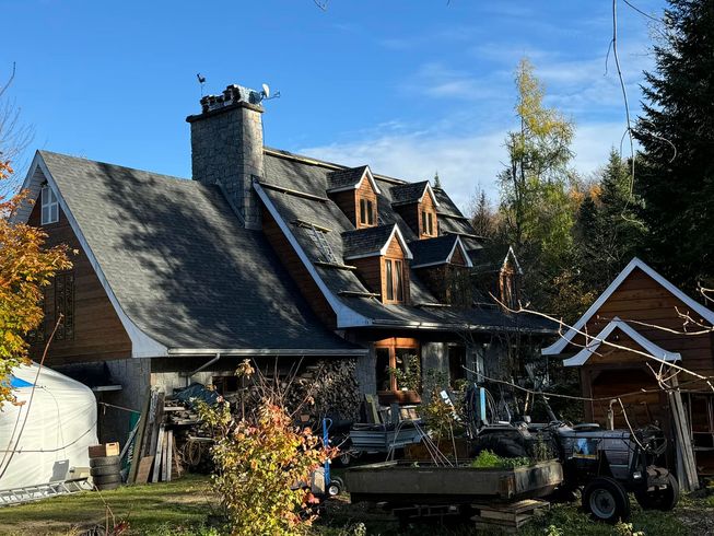 Une grande maison avec un tracteur garé devant