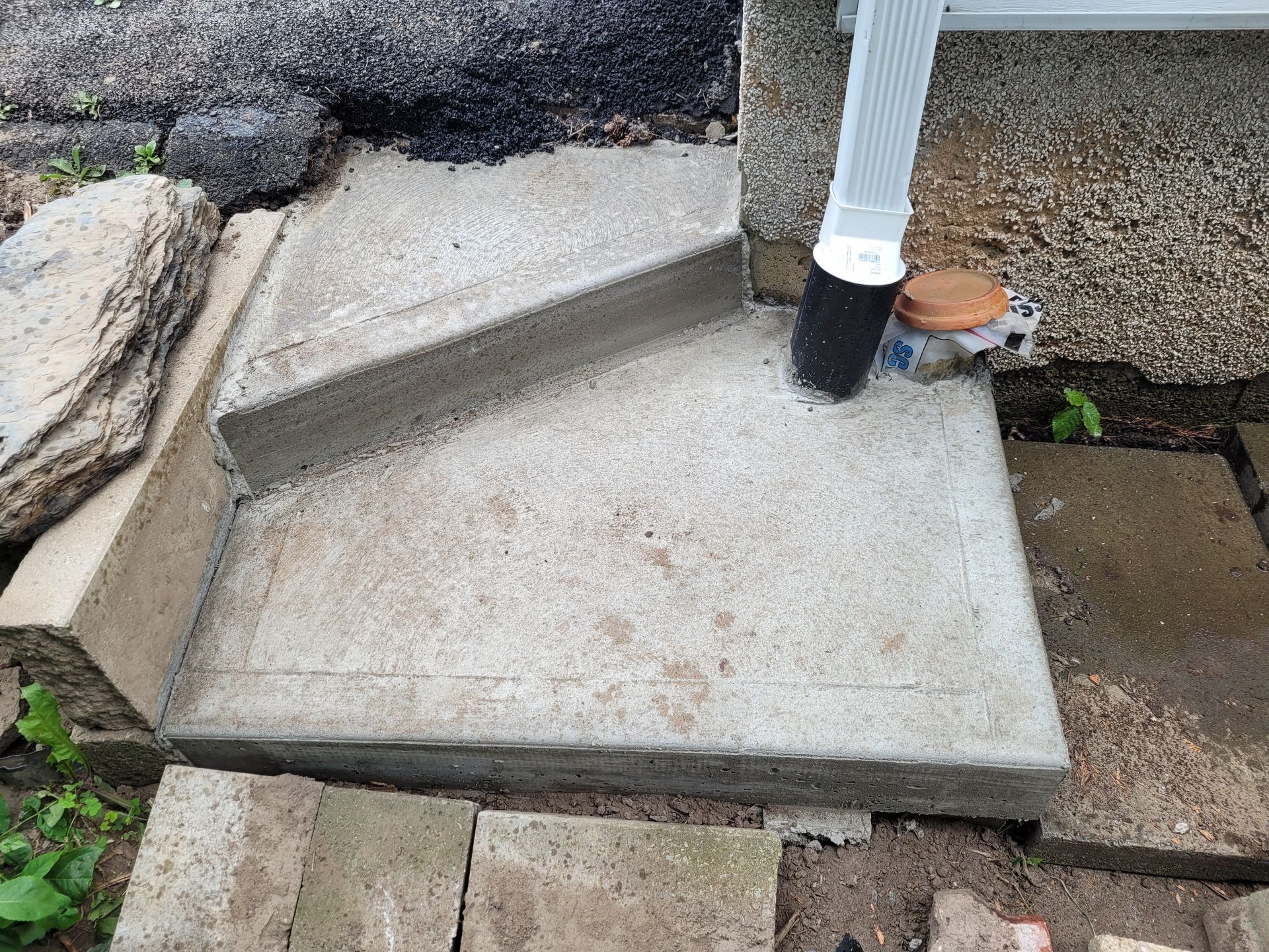 Un escalier en béton avec un tuyau d'évacuation sur le côté.
