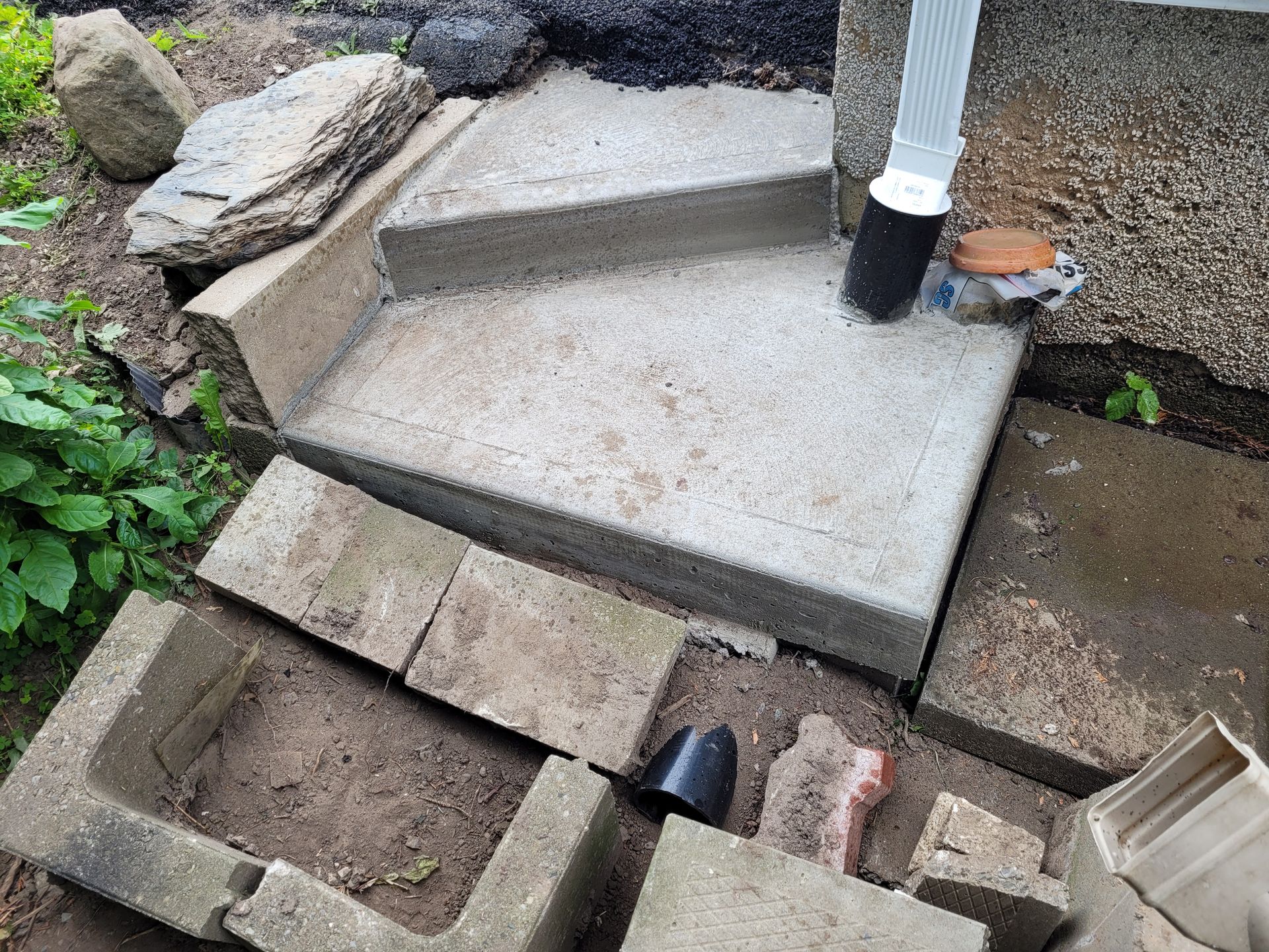 Un ensemble de marches en béton posées sur un tas de briques.