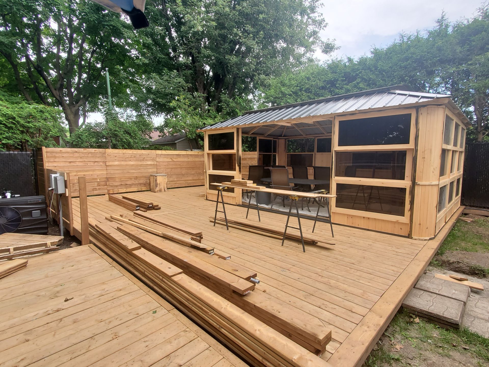 Une terrasse en bois avec un gazebo en arrière-plan.