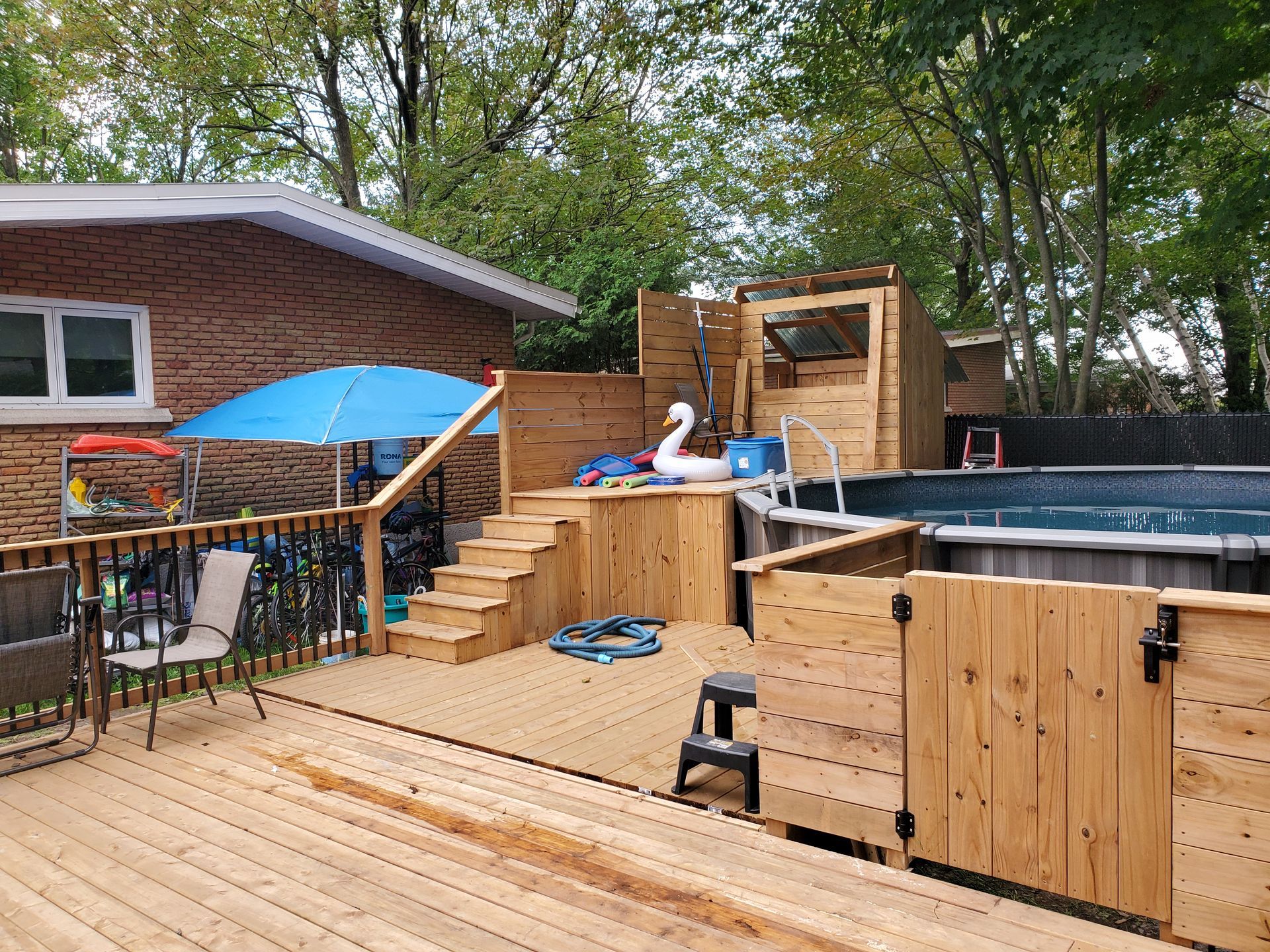 Une terrasse en bois avec une piscine dans l'arrière-cour d'une maison.