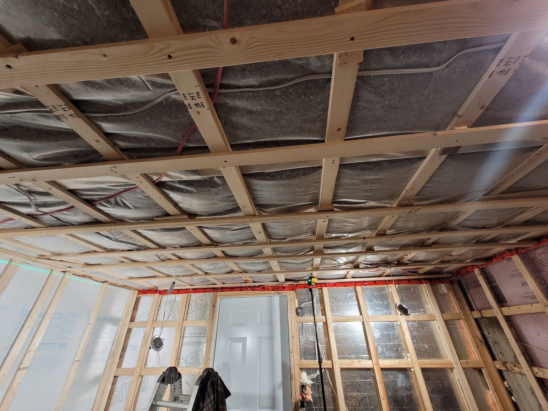 Une pièce en construction avec une ossature bois et une échelle.