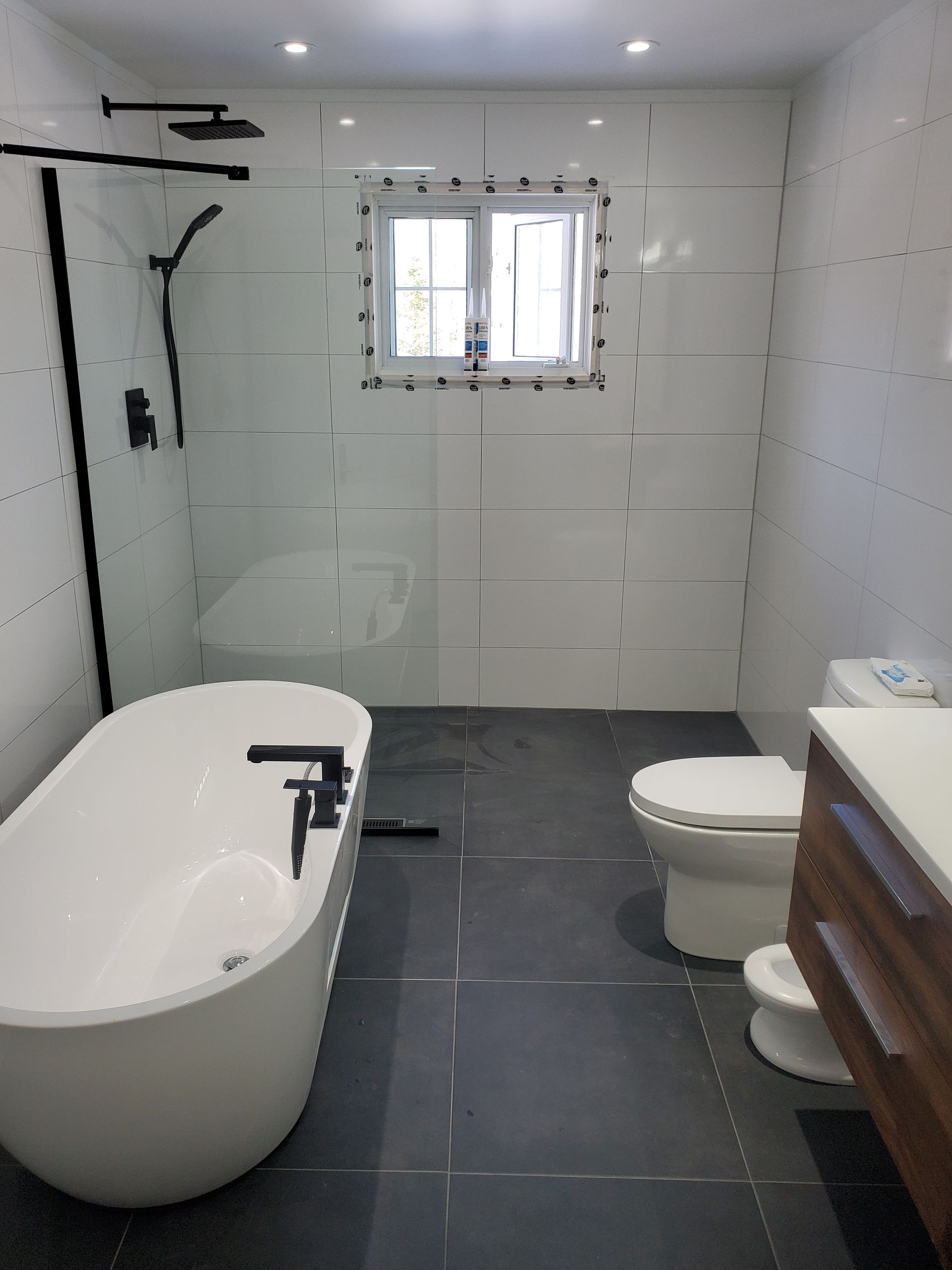 Une salle de bain avec une baignoire, des toilettes et une fenêtre