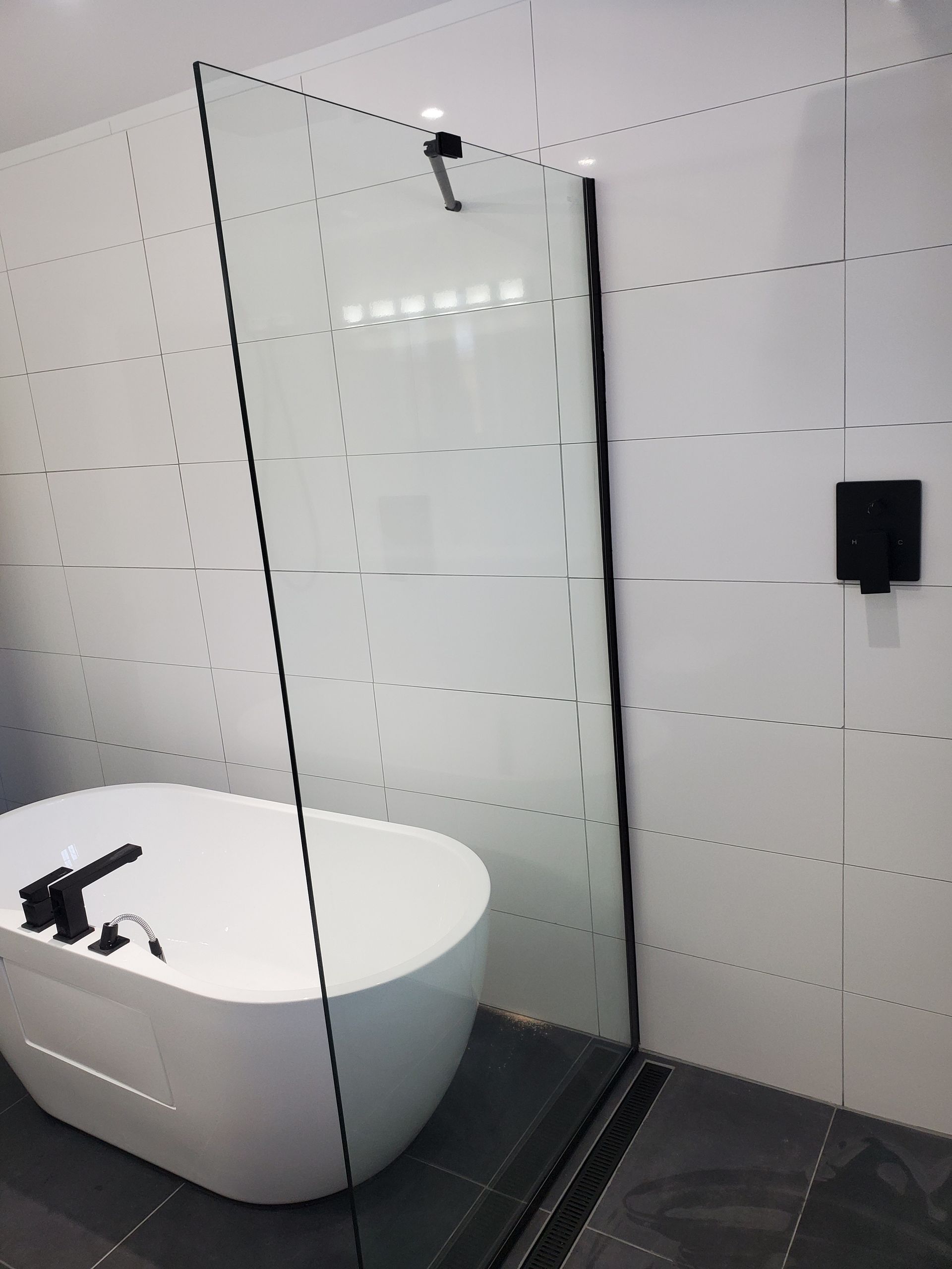 Une salle de bain avec baignoire et douche à l'italienne.