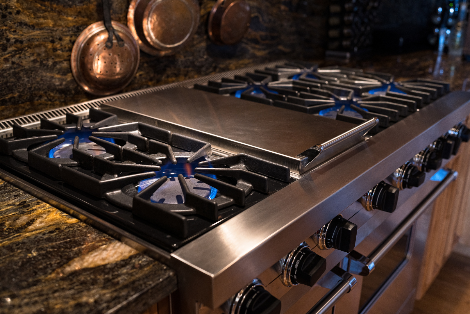 A stove top oven is sitting on top of a granite counter top.