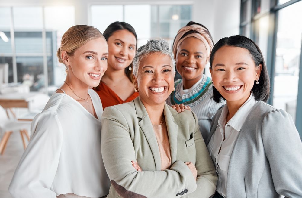 Group of smiling women in office setting.