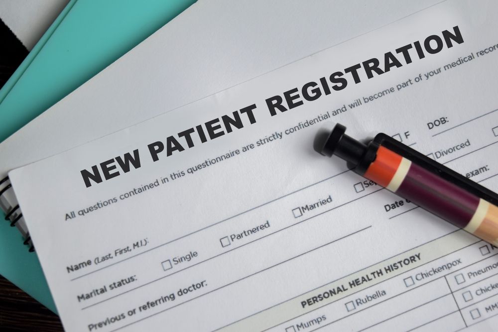 New patient registration form with pen on top, ready for completion.