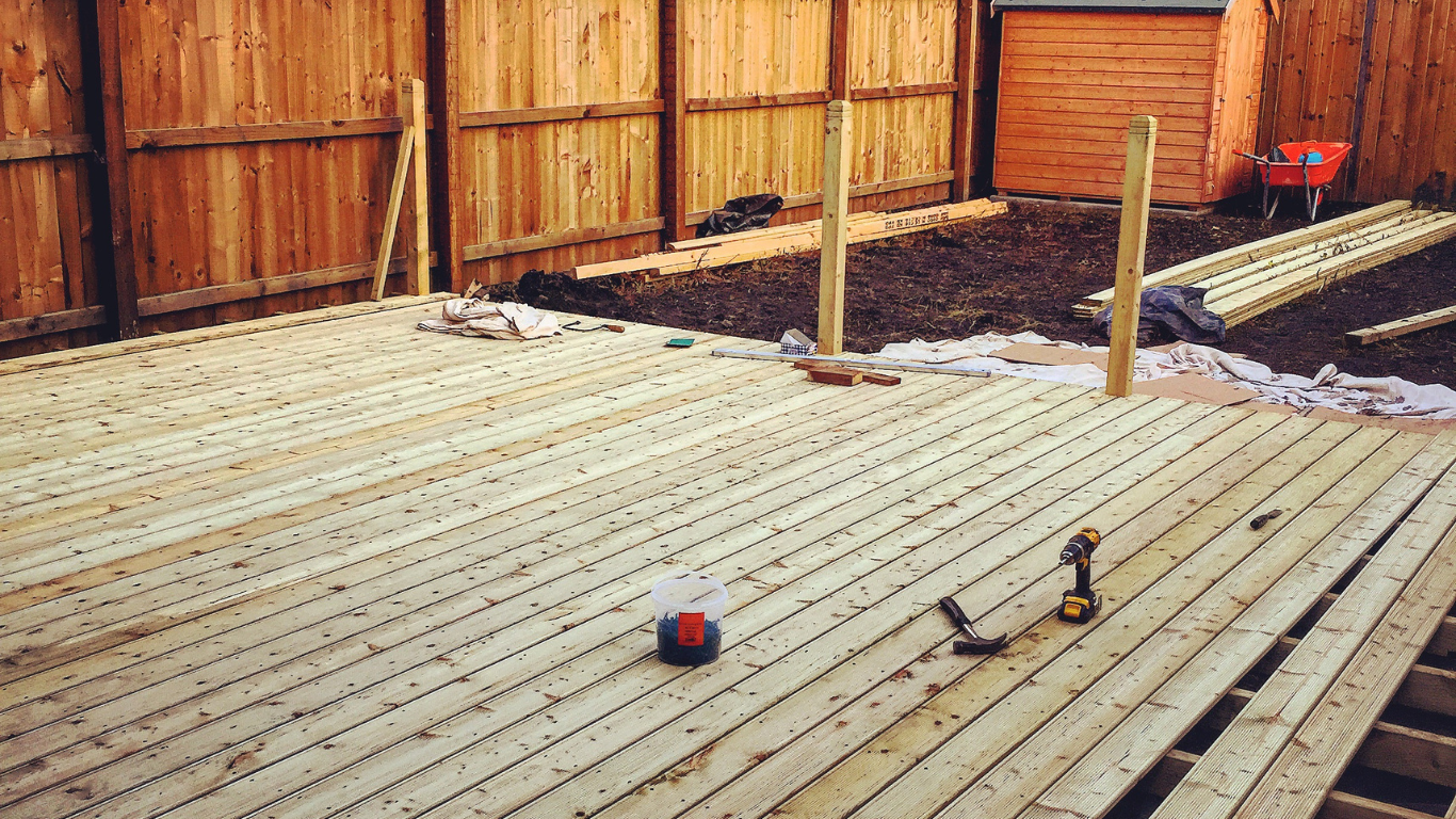 A wooden deck is being built in a backyard.