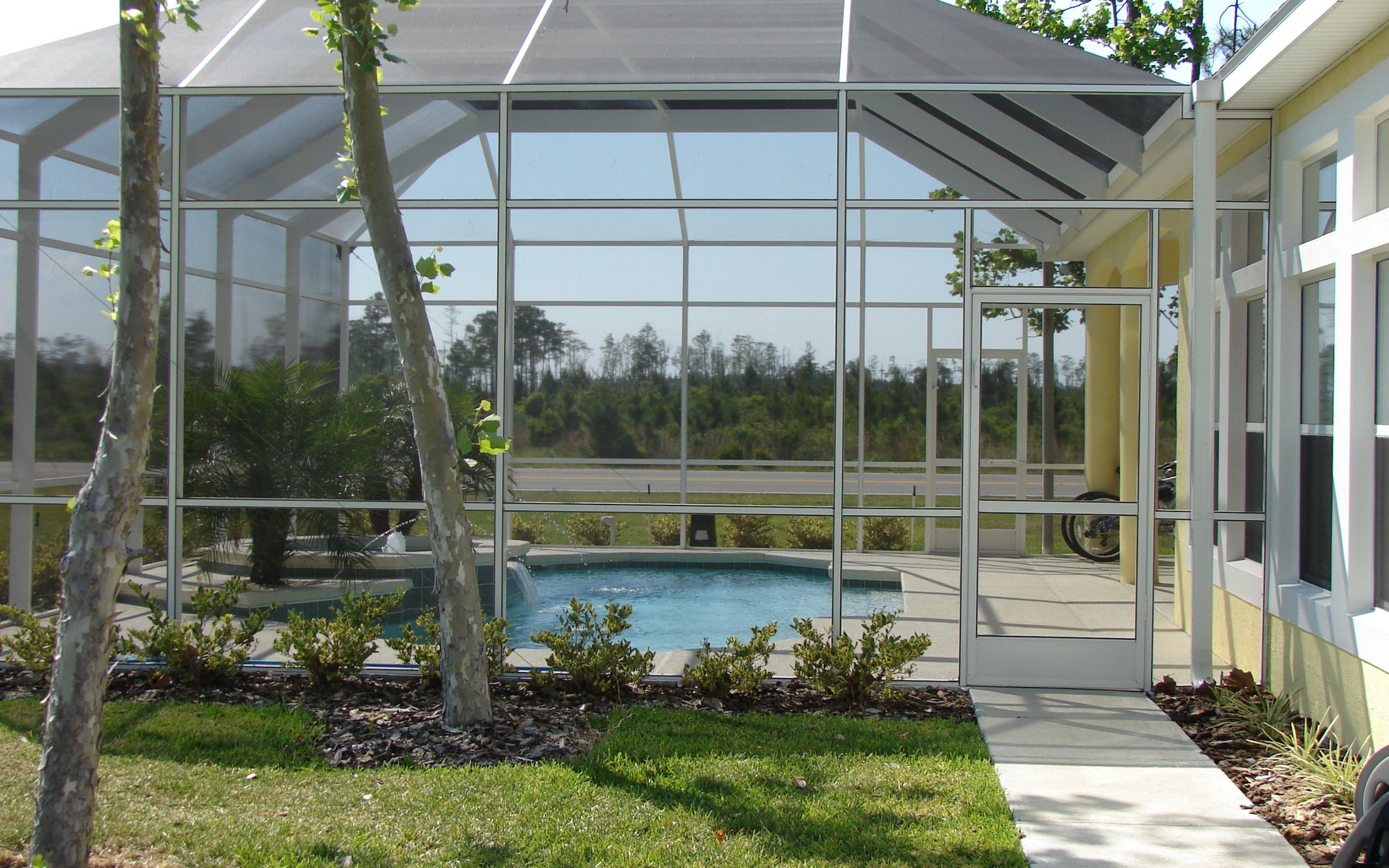 A screened in area with a swimming pool in the background