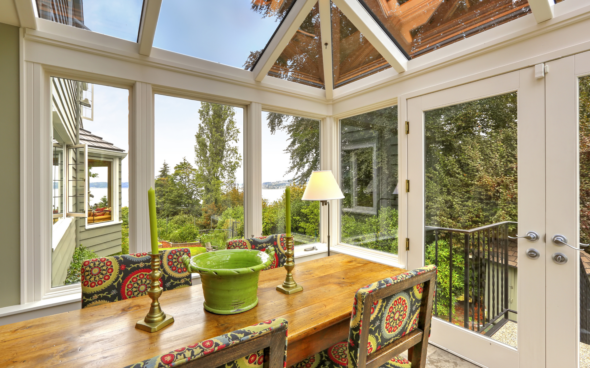 A dining room with a table and chairs and a green bowl on the table.