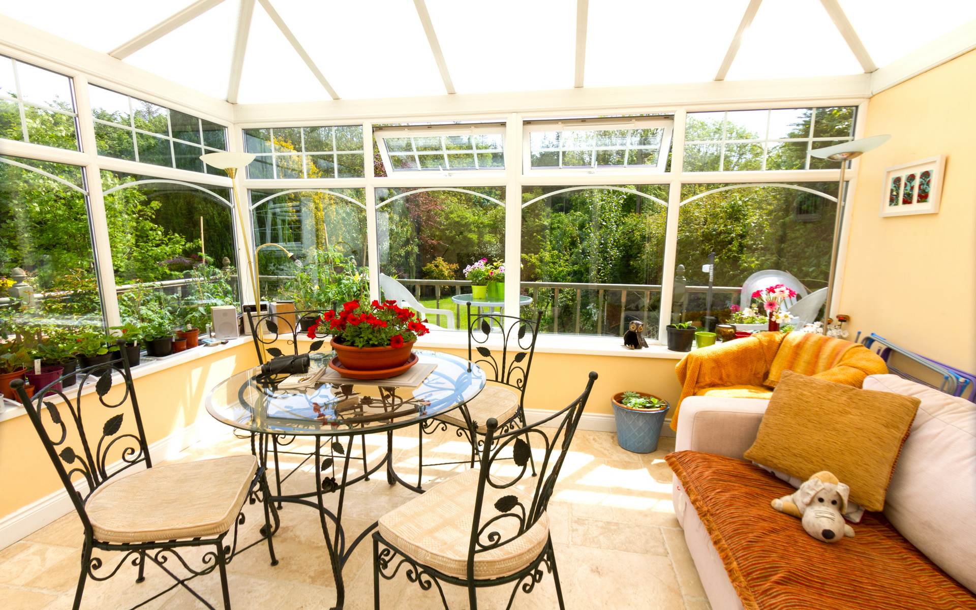 A living room with a table and chairs and a dog on the couch