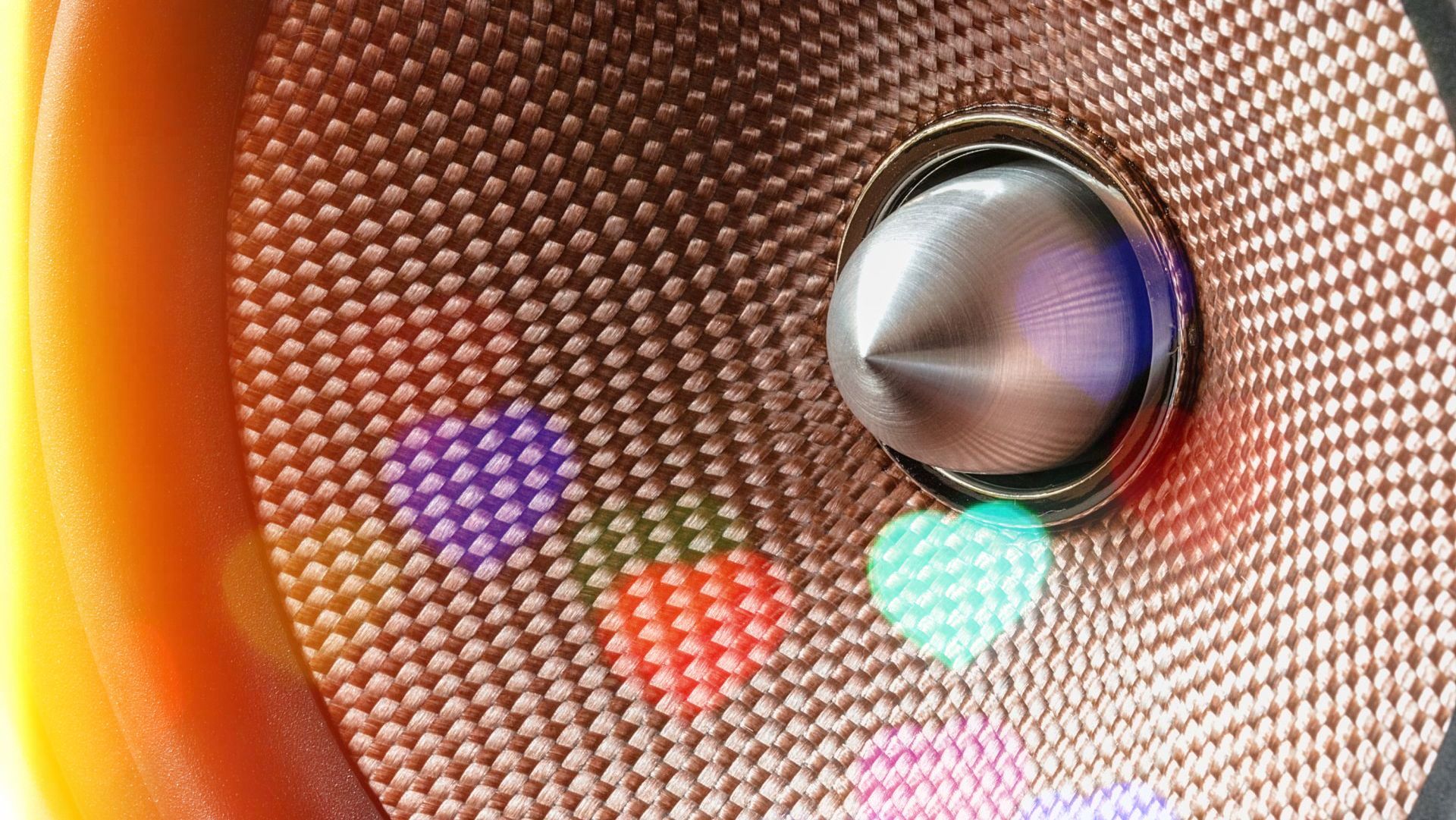 a close up of a speaker with colorful lights behind it