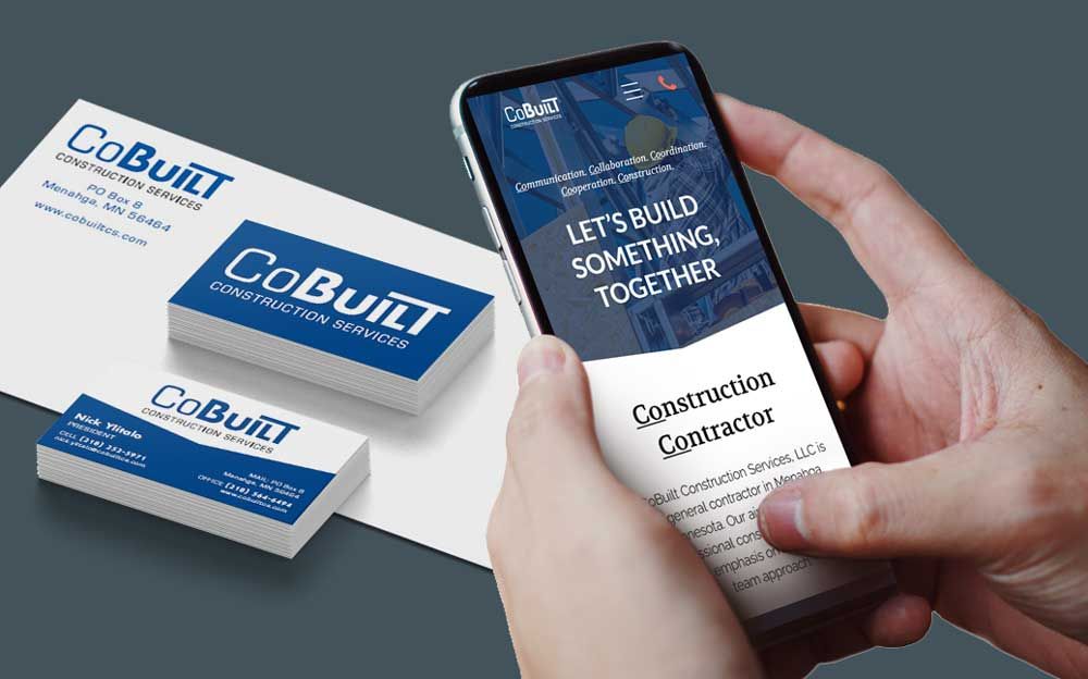 Hands holding smartphone displaying CoBuilt website next to business cards and envelope.
