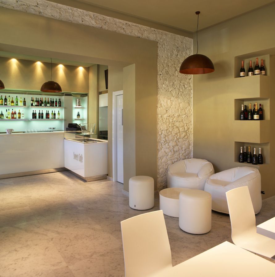 Una stanza con un tavolo, sedie e bottiglie sugli scaffali