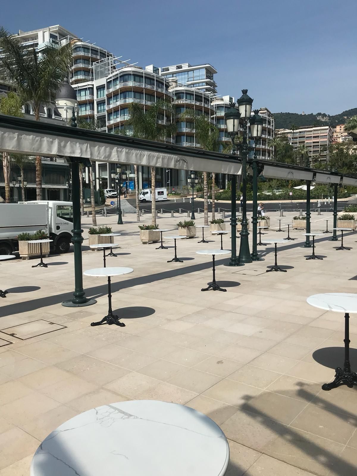 Una fila di tavoli e sedie su un patio con un edificio sullo sfondo.