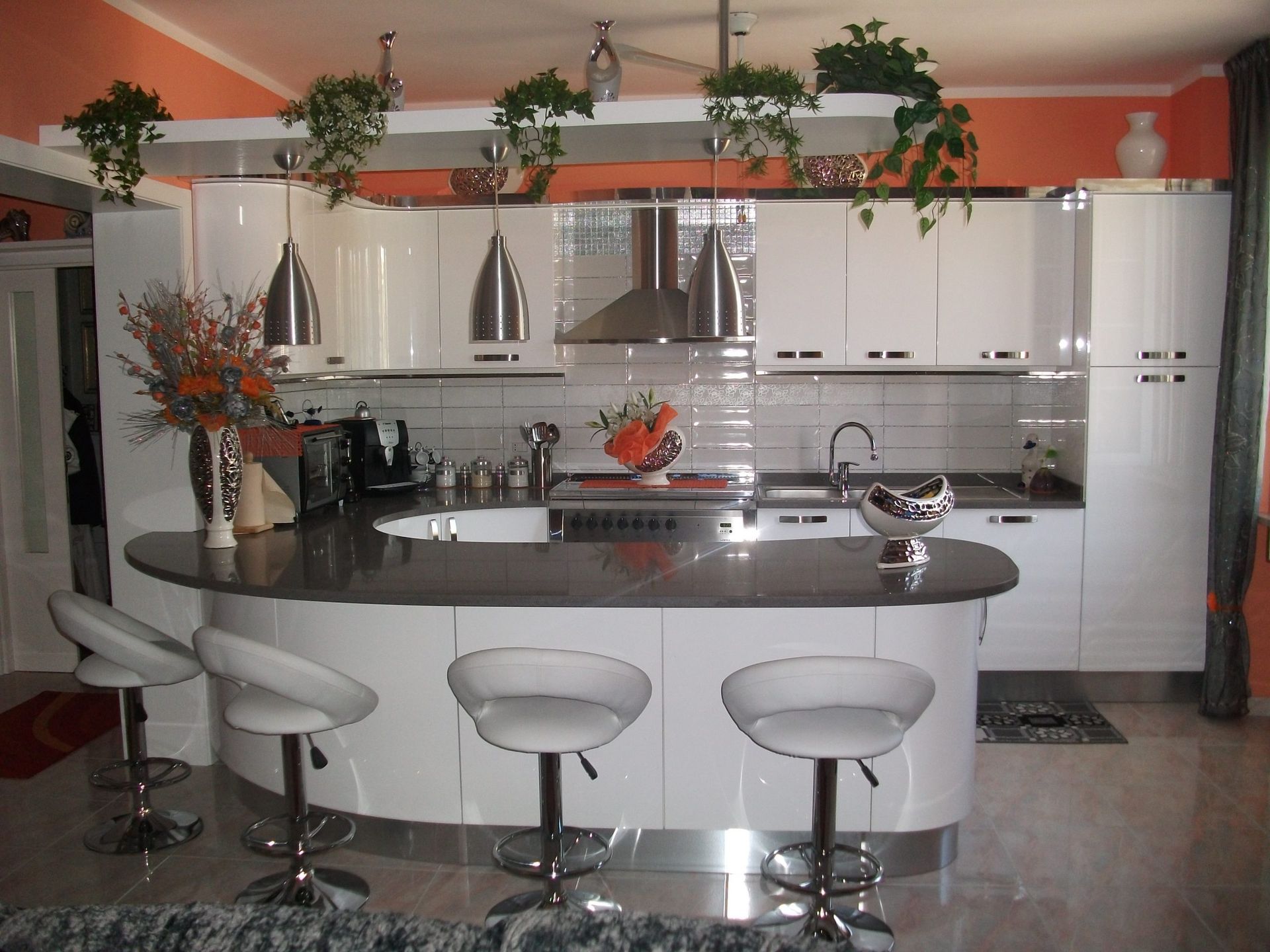 Una cucina con mobili bianchi e ripiani neri