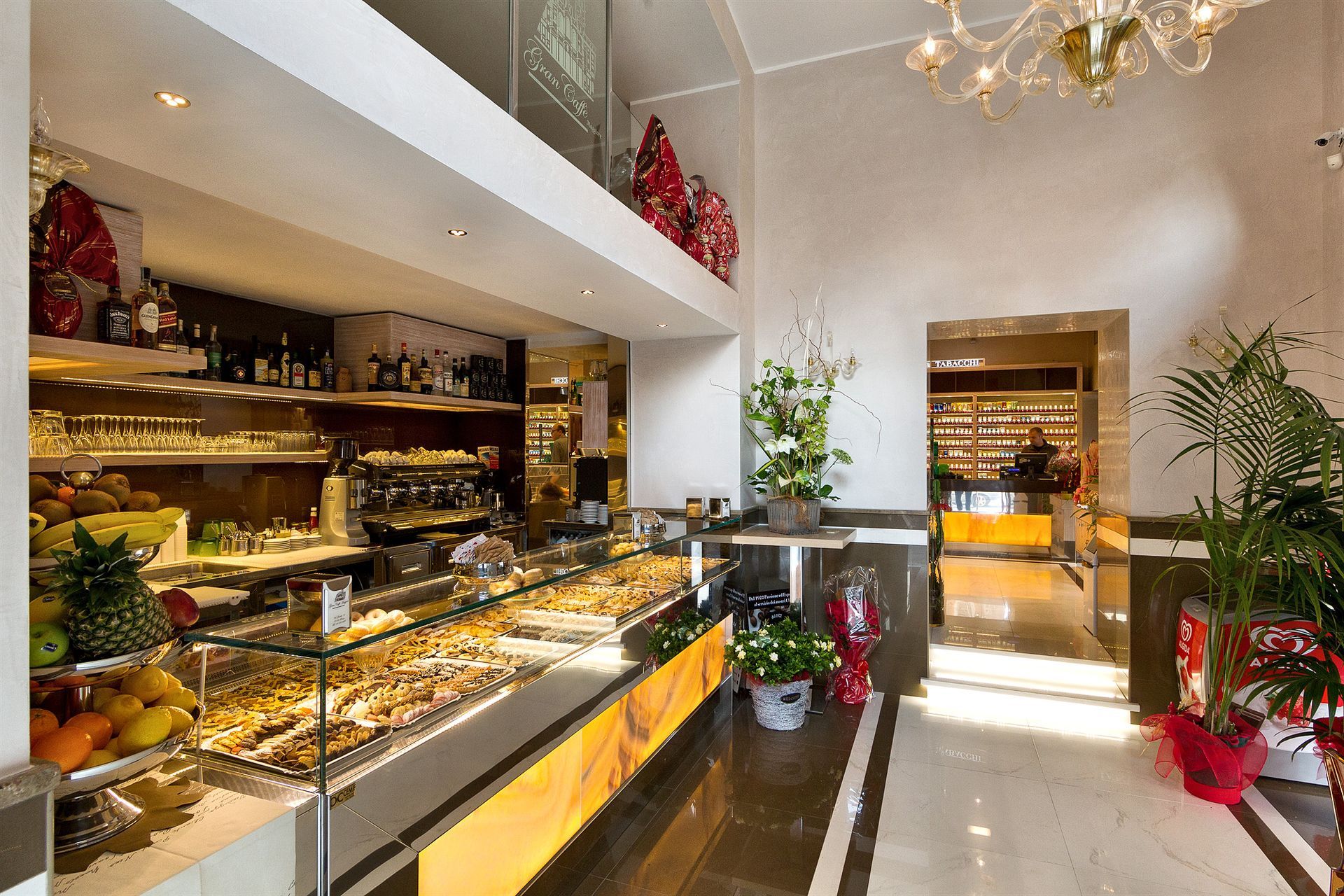 Una panetteria con un bancone di vetro e un lampadario