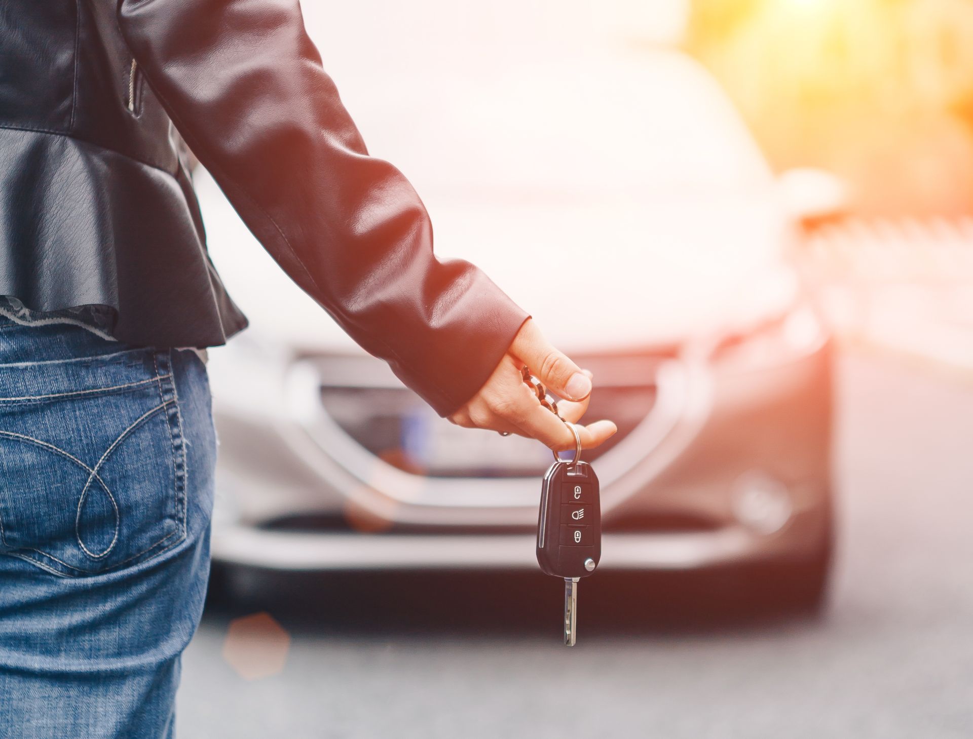 lady holding car key in front of the car