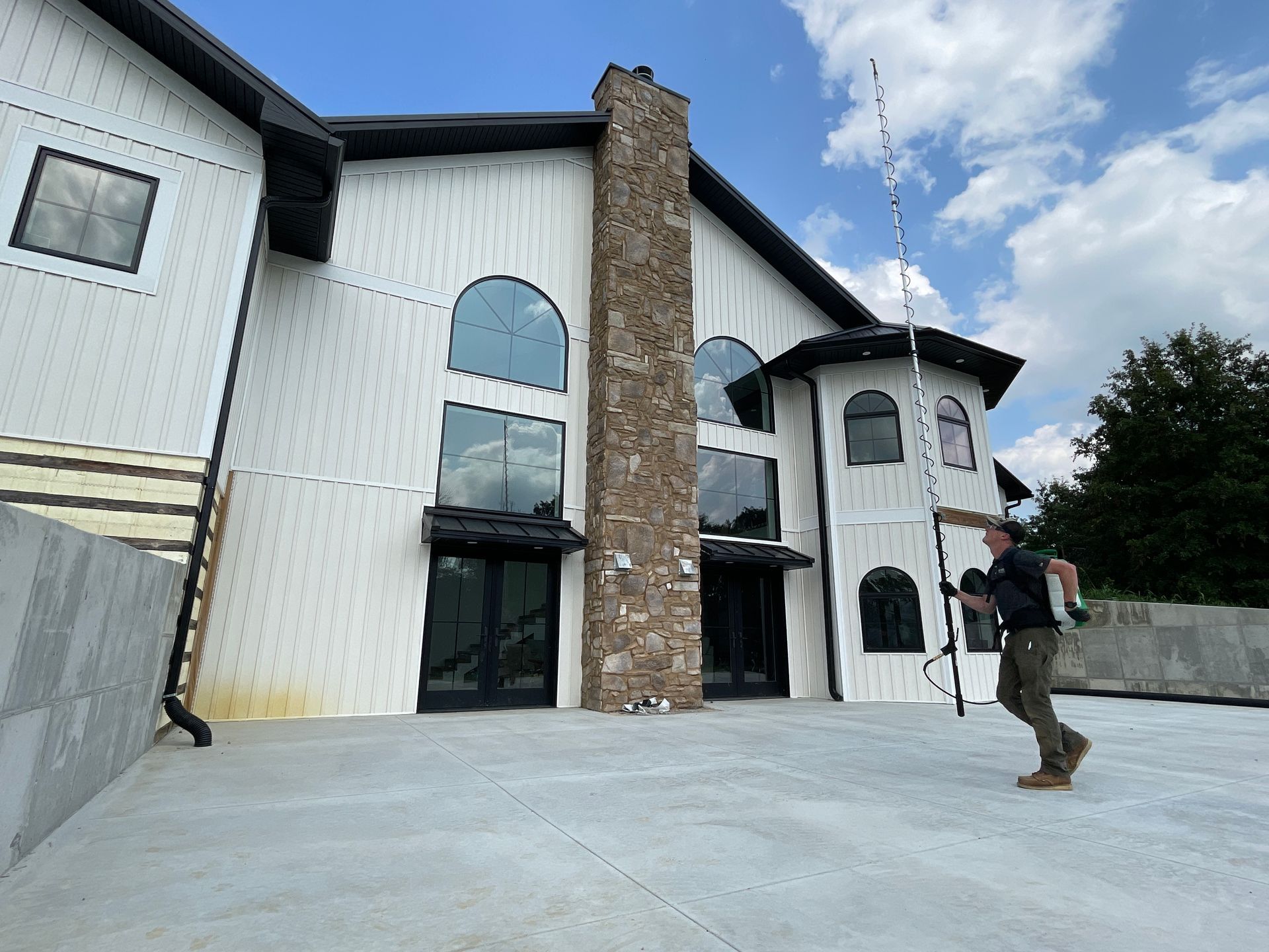 A man is standing in front of a large white building.