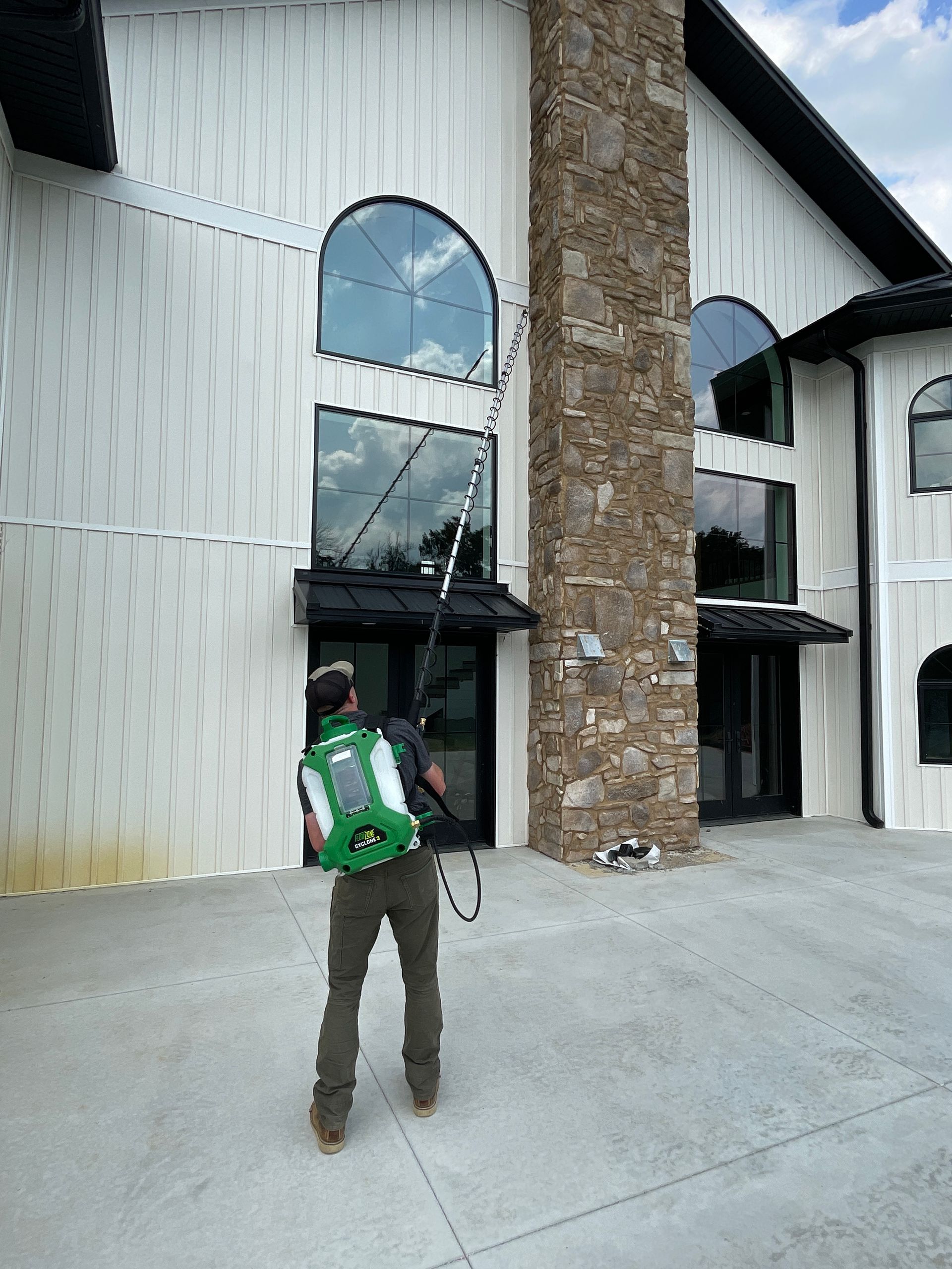 A man is cleaning the windows of a large building.