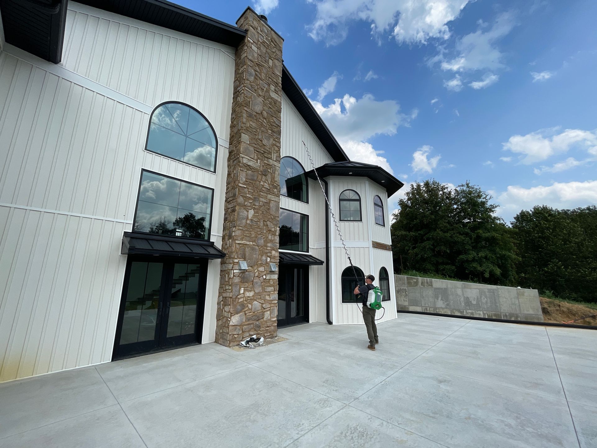 A man is standing in front of a large white building.