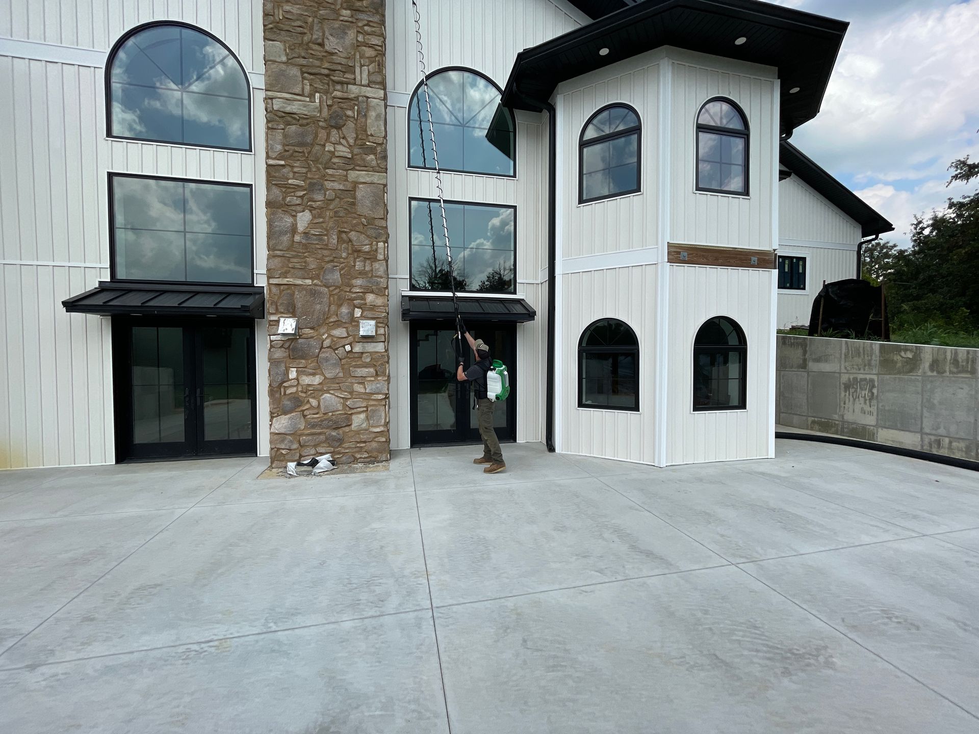 A man is cleaning the windows of a large white building.