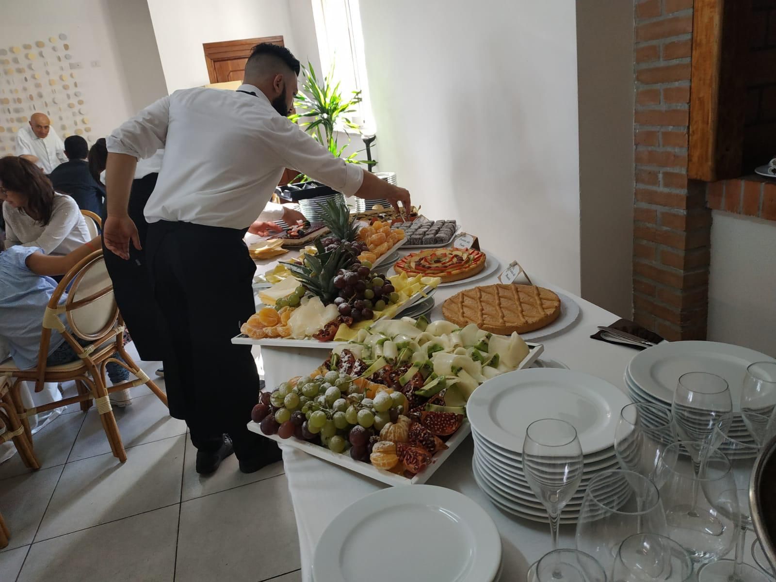 Barista che versa da due bottiglie in uno shaker al bar.