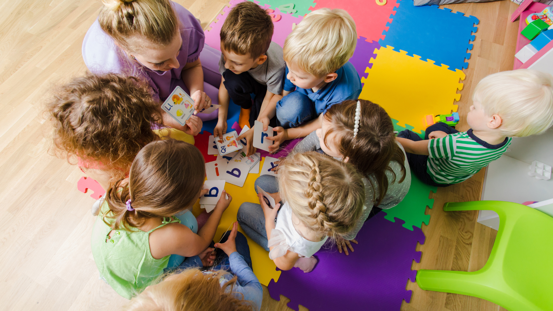 A group of children are sitting on the floor in a circle playing a game.