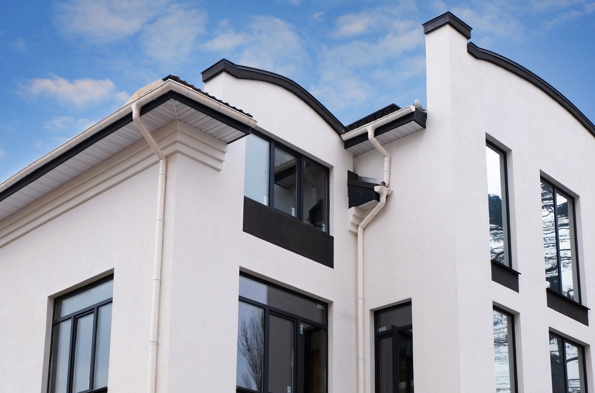 A white house with black windows and a blue sky in the background