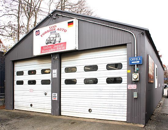 Exterior of Yanis Foreign Auto with a drop box and open door.