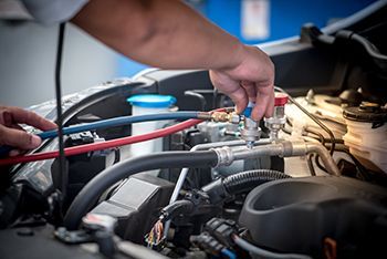 A person is working on the engine of a car.