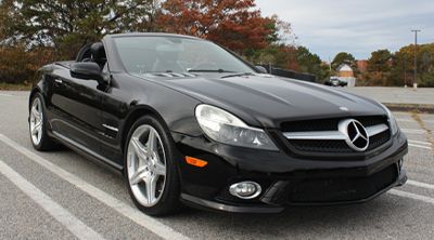 Black Mercedes SL convertible parked in a parking lot.