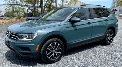 a silver porsche 911 carrera s is parked on a showroom floor .