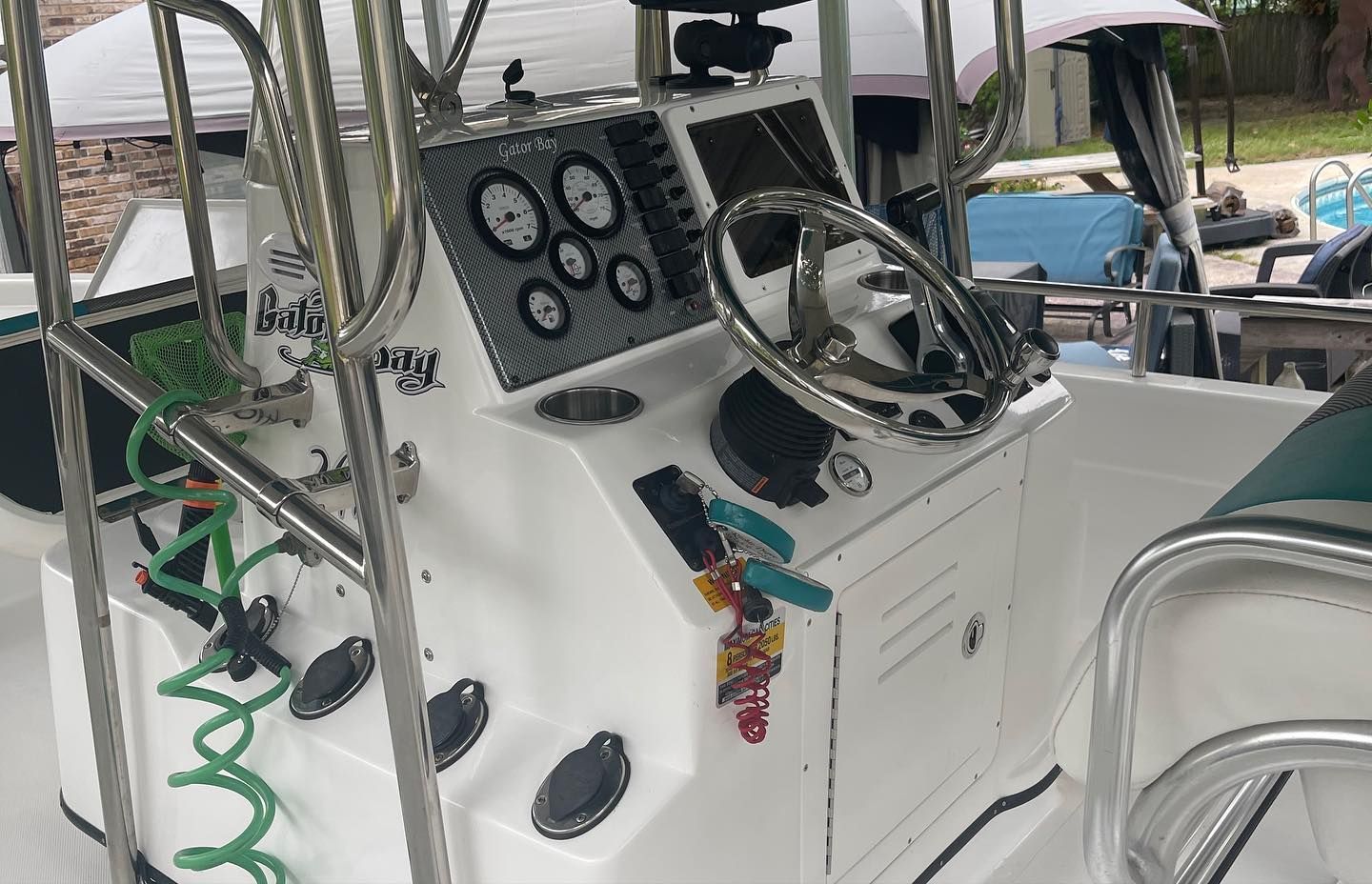 A white boat with a steering wheel and a hose attached to it.