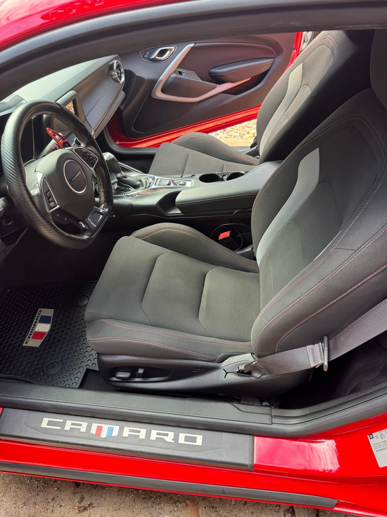 The interior of a red camaro with the door open
