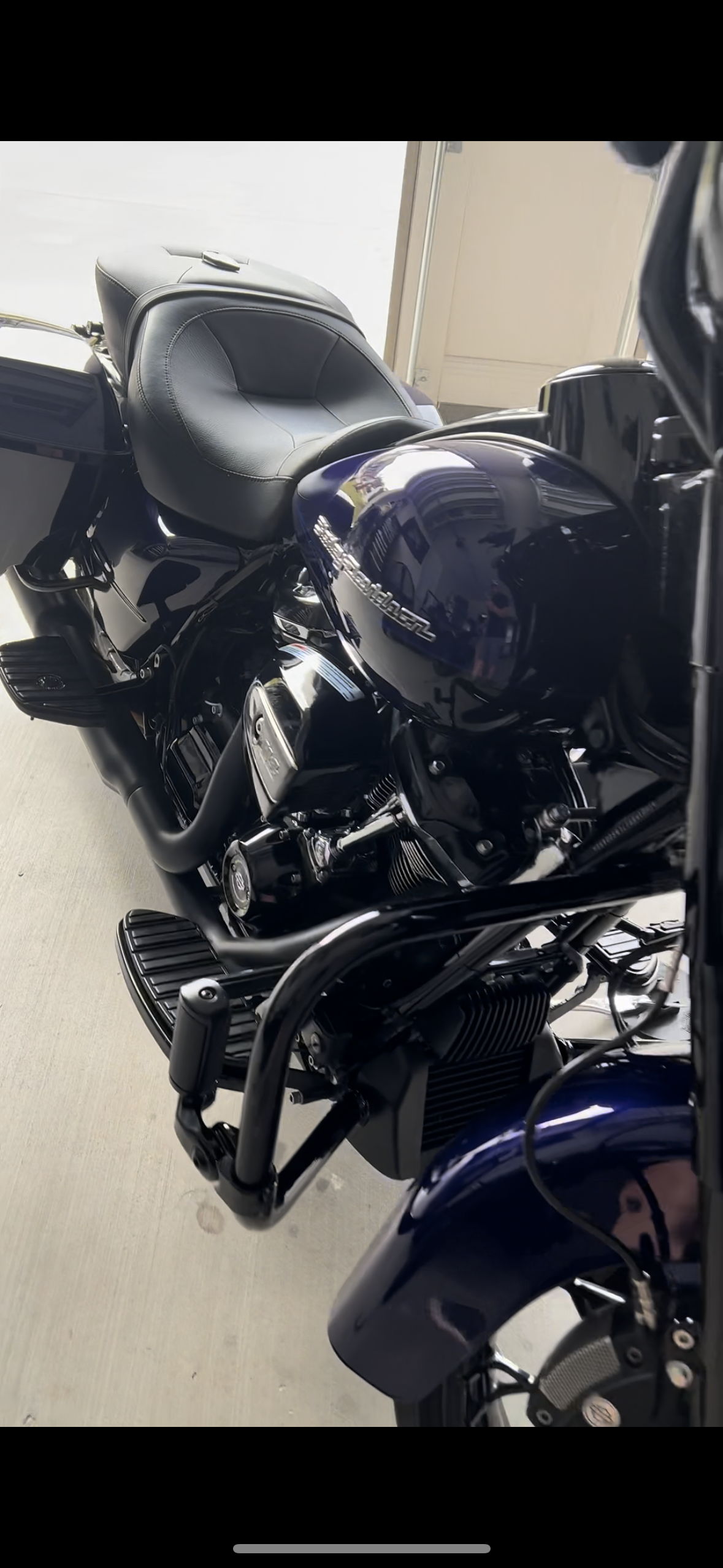 A blue harley davidson motorcycle is parked in a garage.